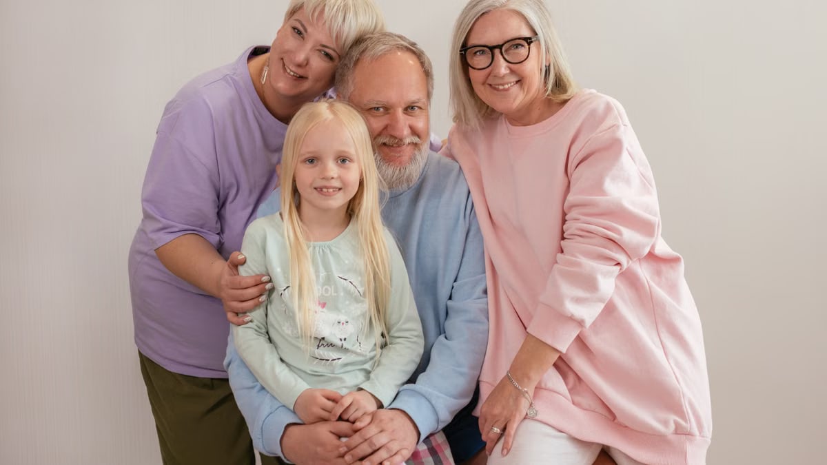 A happy multigenerational family posing indoors with smiles and affection.